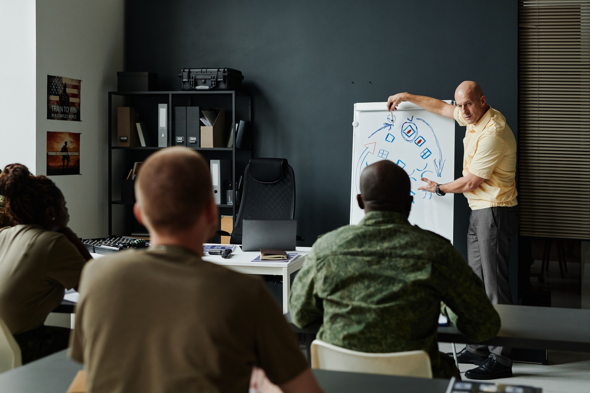 Mature coach standing in front of audience during explanation of tactics